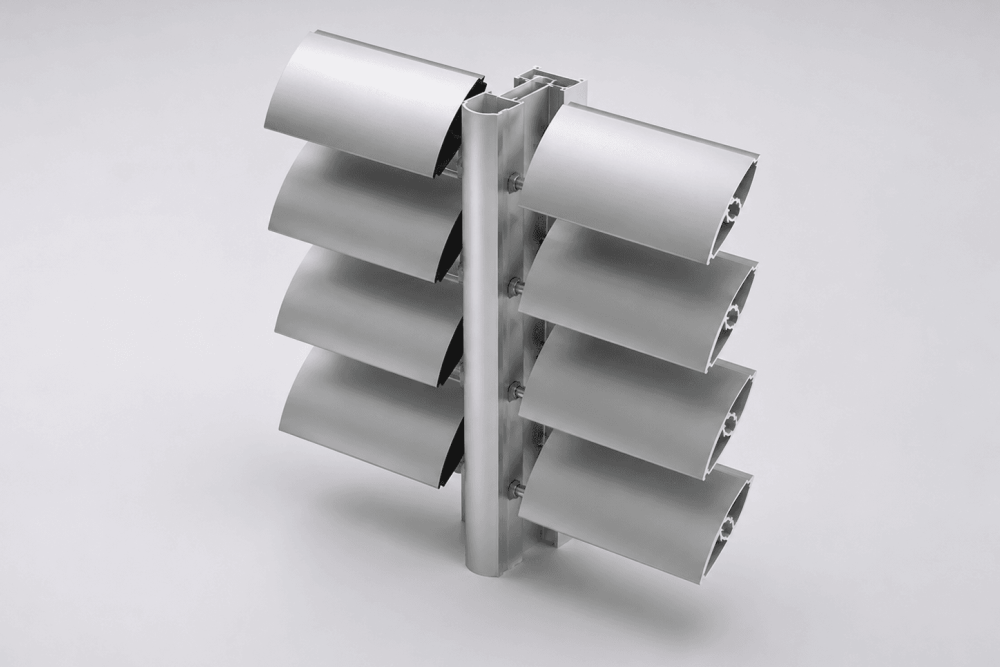 A metal cylindrical pole with six attached rectangular metal fins, three on each side, arranged in pairs and evenly spaced vertically against a plain light gray background.